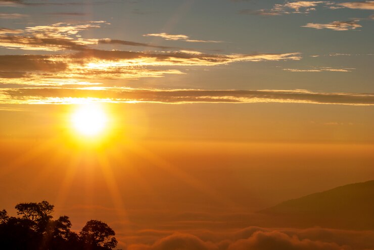 Foto o sol da manhã subindo, havia nuvens e picos de montanhas contra um padrão borrado.