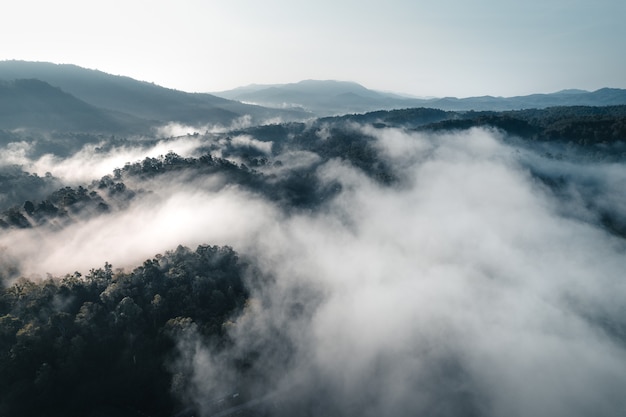 O sol nasce na névoa e nas montanhas pela manhã, nevoeiro matinal