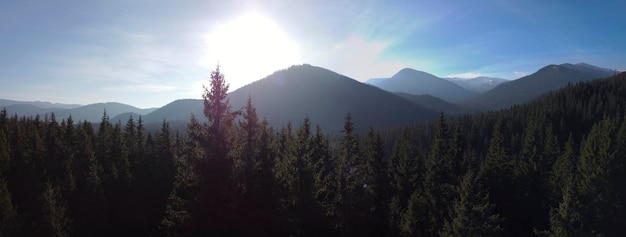 O sol nascendo por trás das montanhas uma vista do topo da montanha que é seguida pelos topos das árvores