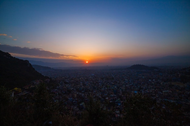 O sol se põe sobre uma cidade nas montanhas.