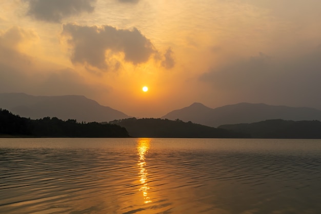 O sol tingiu o céu e a água de dourado