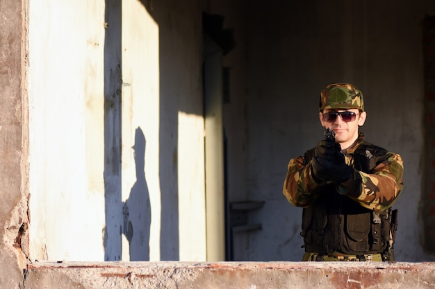 O soldado está atirando com a arma