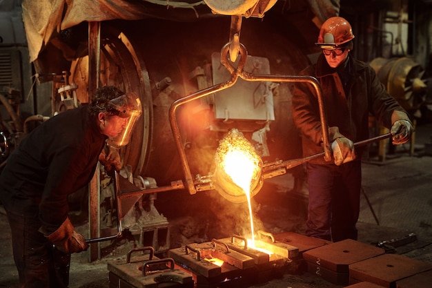 O soldador trabalha na oficina de dois trabalhadores siderúrgicos derretendo metal