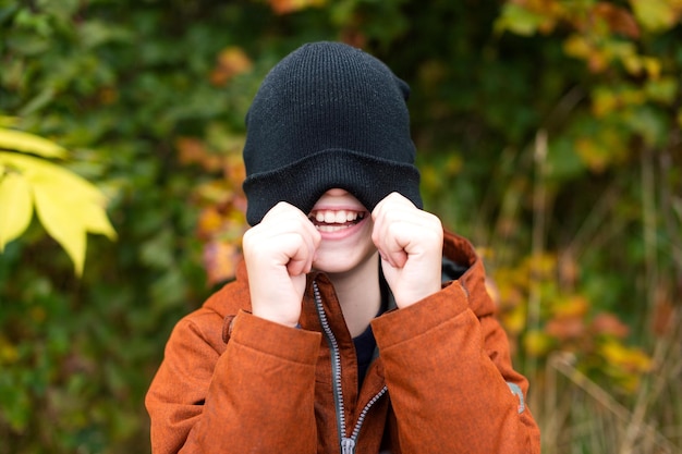 O sorriso de uma criança sob um chapéu no rosto