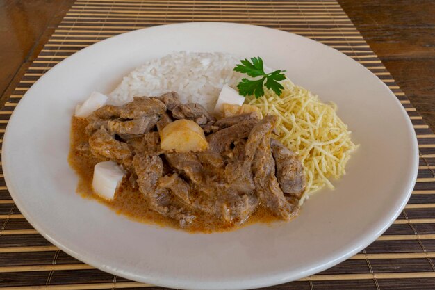 O strogonoff de carne com creme de tomate palmito arroz de dendê e batata frita