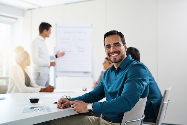 O sucesso é algo realmente bom Retrato de um jovem empresário tendo uma reunião com seus colegas em um escritório