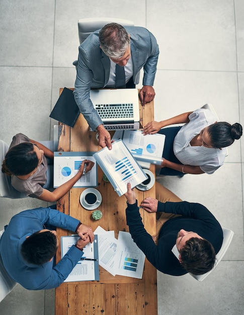 Foto o sucesso está no topo de sua agenda foto de alto ângulo de um grupo de empresários tendo uma reunião em um escritório