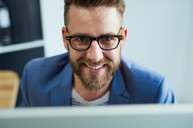 O sucesso será meu em breve retrato de um jovem empresário trabalhando em um computador em um escritório