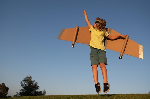 O super-herói infantil salta e voa com jetpack Piloto infantil brinca no dia de verão Líder de sucesso e conceito de vencedor Imaginação e liberdade