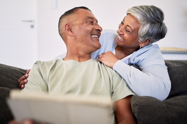 Foto o tablet do amor e o feliz casal sênior se relacionando relaxam e verificam o artigo de notícias por e-mail e aproveitam o contato visual da aposentadoria história do site compras on-line e homem idoso velha ou pessoas sorriem em casa