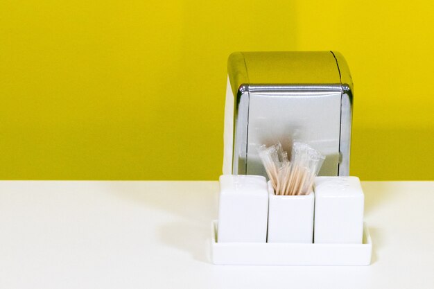 Foto o tampo de uma mesa de restaurante ou café montado em um fundo branco com espaço de cópia inclui porta-guardanapos, saleiro e pimenteiro. conceito de serviço de alimentação.