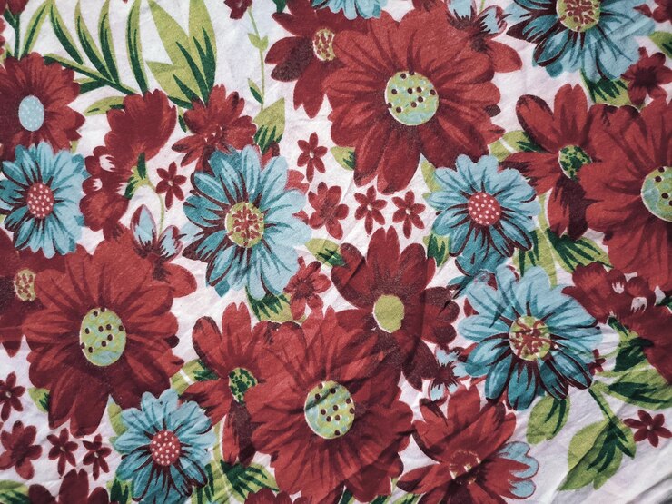 Foto o tecido básico é branco com motivos florais e folhas vermelhos e azuis
