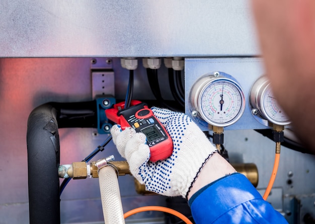 O técnico verifica as linhas de energia do trocador de calor com pinças de corrente