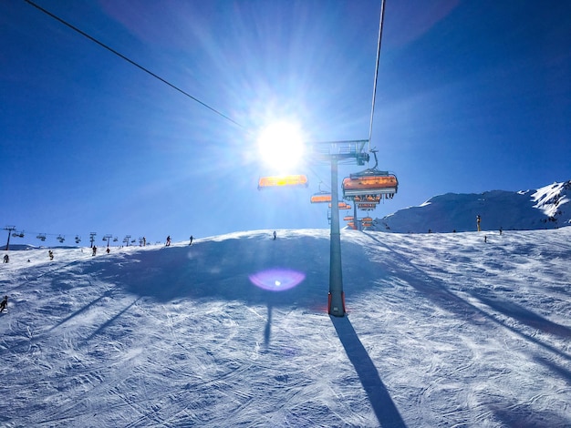 O teleférico aéreo em um campo coberto de neve contra um céu claro