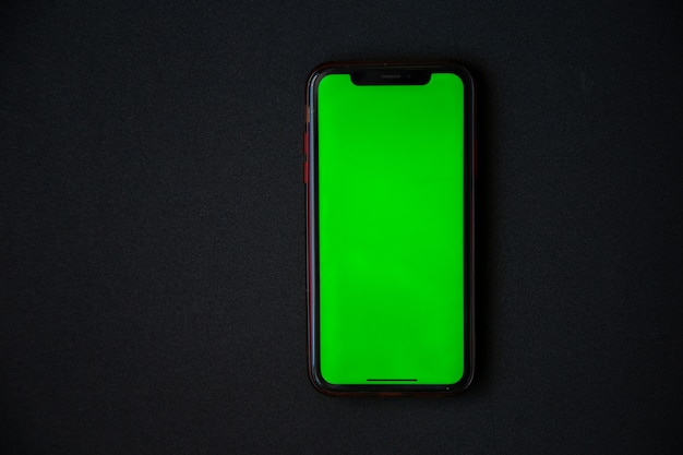 O telefone com uma tela verde está em uma foto de alta qualidade de fundo preto