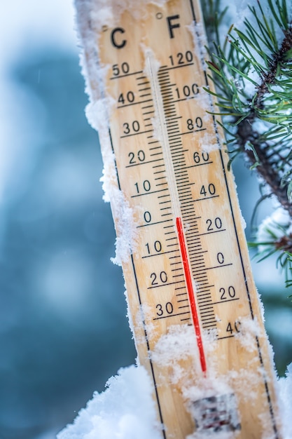 Foto o termômetro na neve mostra baixas temperaturas em celsius ou farenheit.