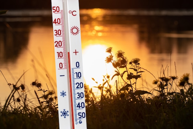 O termômetro no fundo do rio no outono, durante o pôr do sol, mostra uma temperatura de 15 graus