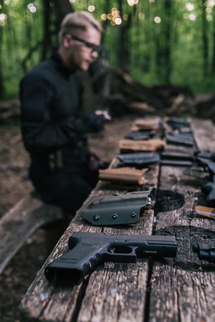 O tipo na floresta está a testar as armas para tiro ao esporte.