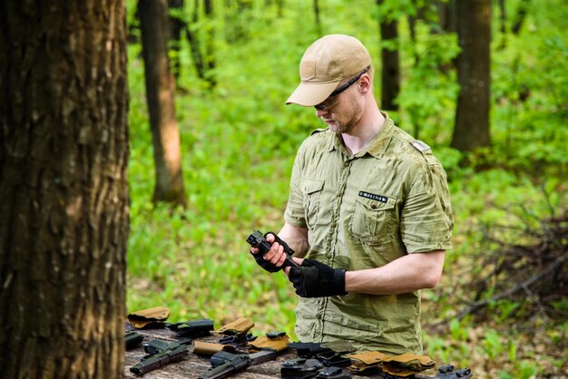 O tipo na floresta está a testar as armas para tiro ao esporte.