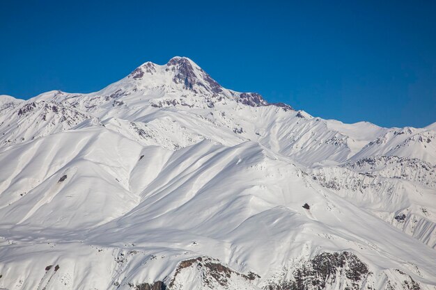 O topo do Monte Kazbek com as montanhas do Cáucaso cobertas de neve