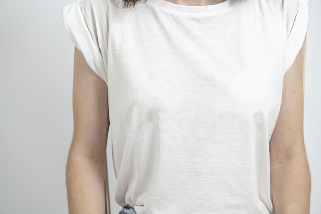 O torso de uma mulher vestindo uma camiseta branca lisa