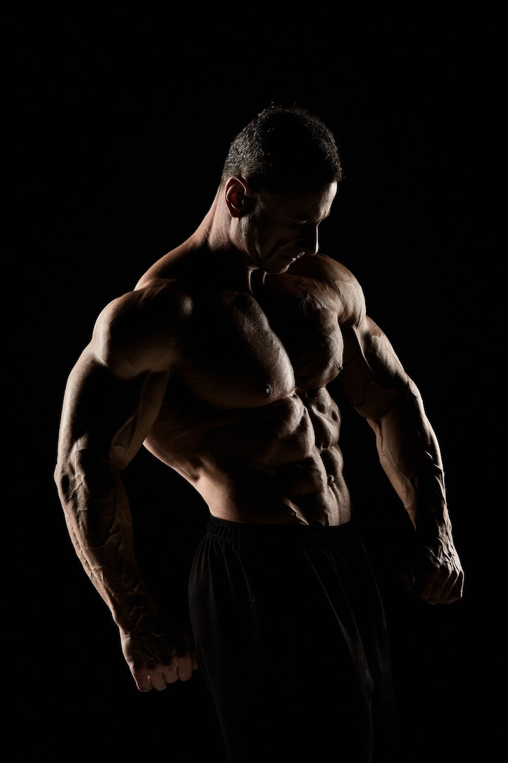 Foto o torso do construtor de corpo masculino atraente em fundo preto.
