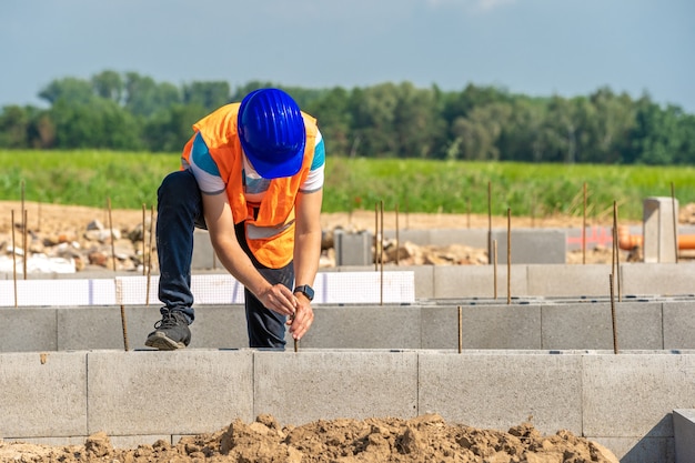 Foto o trabalhador da construção civil constrói a base do edifício.