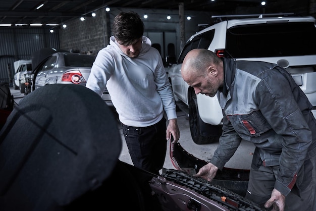 Foto o trabalhador do serviço de carro repara restaura o carro