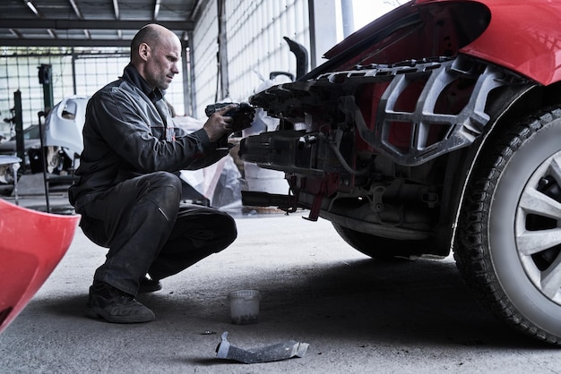 O trabalhador do serviço de carro repara restaura o carro