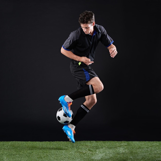 O trabalho duro supera o talento quando o talento não trabalha duro Foto de estúdio de corpo inteiro de um jovem e bonito jogador de futebol isolado em preto