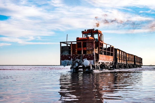 O trem flutua na água contra a mineração de sal da indústria de sal do céu azul