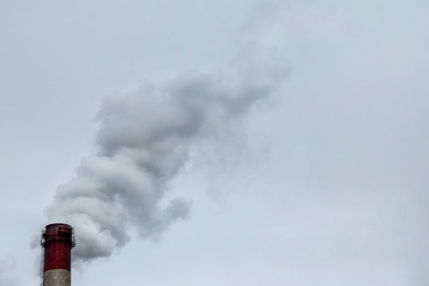 O tubo do qual a fumaça vai contra o céu cinzento