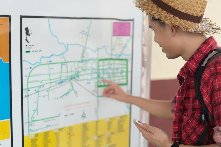 Foto o turista asiático fala o telefone para perguntar a localização e ele está olhando o mapa na estação de trem tailândia homem hipster vai viajar