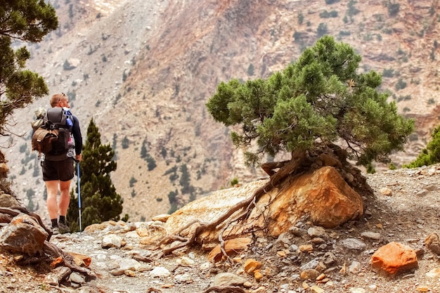O turista de cara com uma mochila faz uma rota nas montanhas do Himalaia Annapurna Circuit Trek