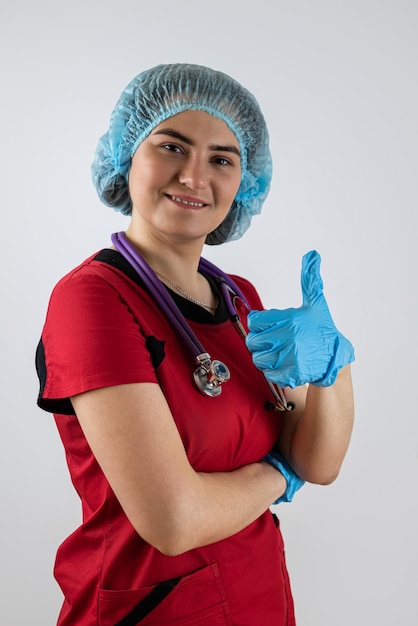 O uniforme da jovem médica mostra o polegar para cima na aprovação dos profissionais de saúde Superando a doença