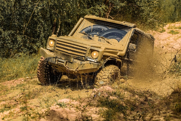 O veículo offroad vai na montanha Pneus em preparação para a corrida Lama e respingos de água no r