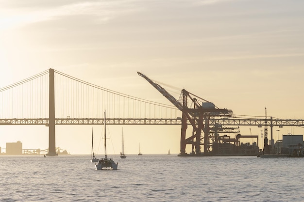 O veleiro navega rio abaixo em guindastes industriais