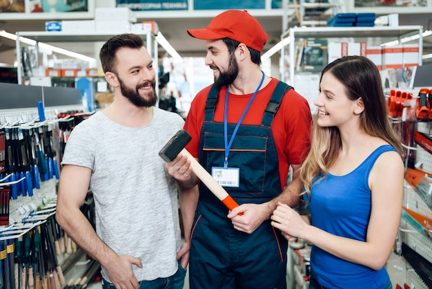 Foto o vendedor está mostrando pares de martelo novo dos clientes.