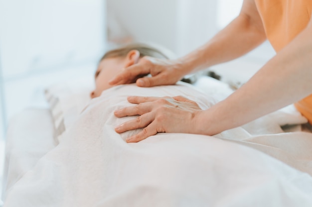 O verdadeiro médico osteopata faz terapia fisiológica e emocional para uma menina de oito anos. sessão de tratamento de osteopatia pediátrica. Medicina alternativa. cuidando da saúde da criança