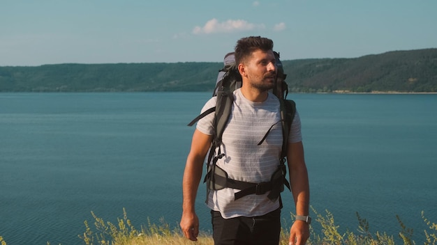 O viajante andando com mochila ao longo da costa