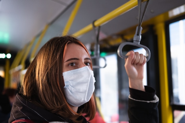 O viajante do sexo feminino usa uma máscara protetora nos transportes públicos. coronavírus, conceito de prevenção de disseminação covid-19, comportamento social responsável de um cidadão