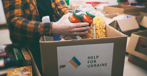 Foto o voluntário embalando a sacola com mantimentos e coisas necessárias para pessoas necessitadas