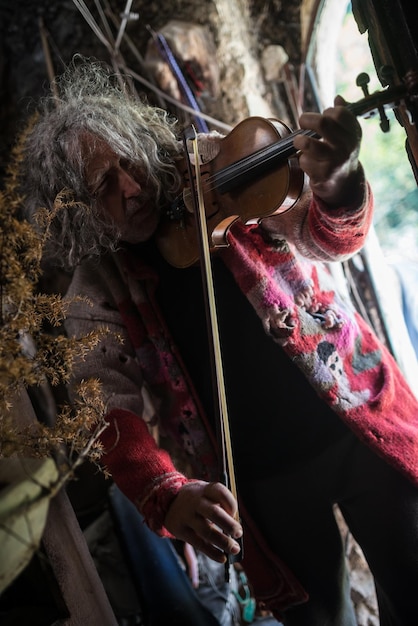 Obdachloser älterer Mann, der Violine spielt