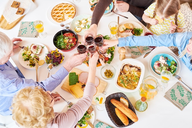 Oben Ansicht der Familie, die beim Abendessen anstößt