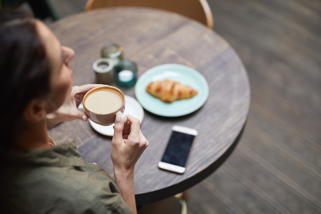 Oben Ansicht der jungen Frau, die Kaffee genießt