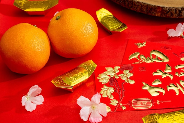 Oben sehen Sie Accessoires des chinesischen Neujahrsfests oder des Mood Day-Festivals in Orangengold und Angpao-Taschen mit Kirschblüten-Zweigdekorationen.