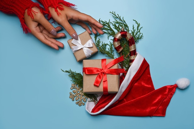 Oben sehen Sie Frau im roten Pullover mit Weihnachtsgeschenken auf blauem Hintergrund.