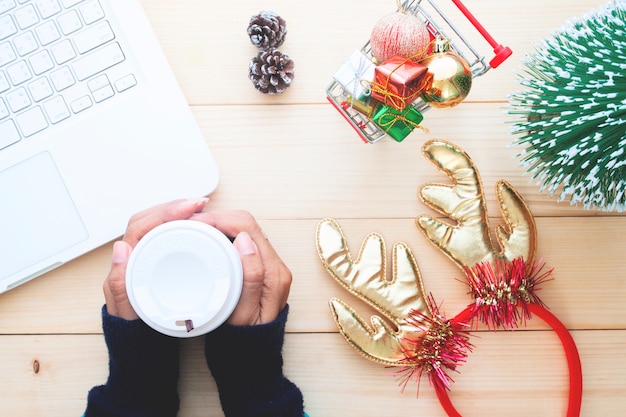 Obenliegende Ansicht des Weihnachtskonzeptes, Lebensstil mit der Frau, die online kauft und trinkender Kaffee