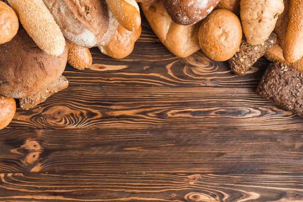 Obenliegende Ansicht von verschiedenen Broten auf hölzernem Hintergrund