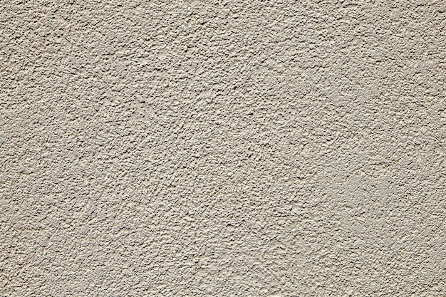Oberfläche der Wand mit beige strukturiertem Putz.